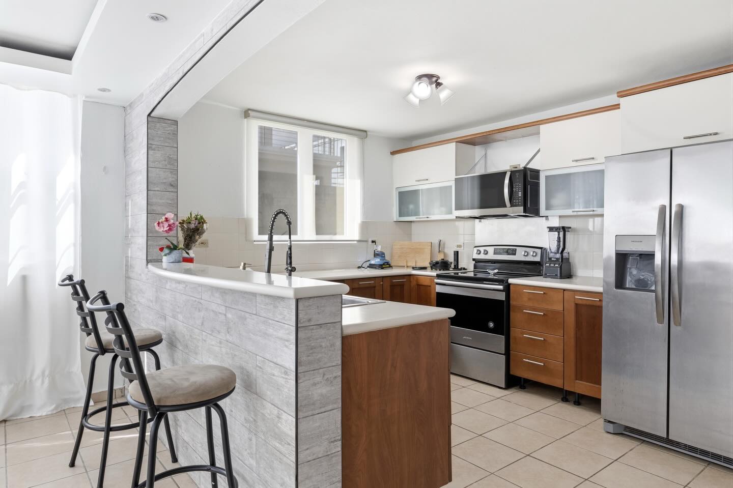 Open kitchen with stainless appliances and breakfast bar